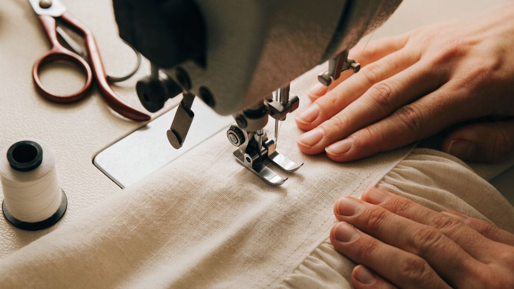 Beginner guiding fabric under a sewing machine presser foot for a straight seam How to Sew a Straight Stitch